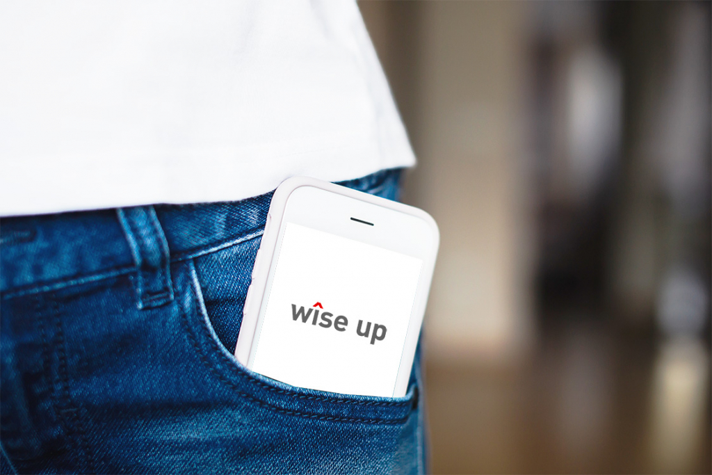 Smartphone in womans Jeans pocket showing wiseup logo
